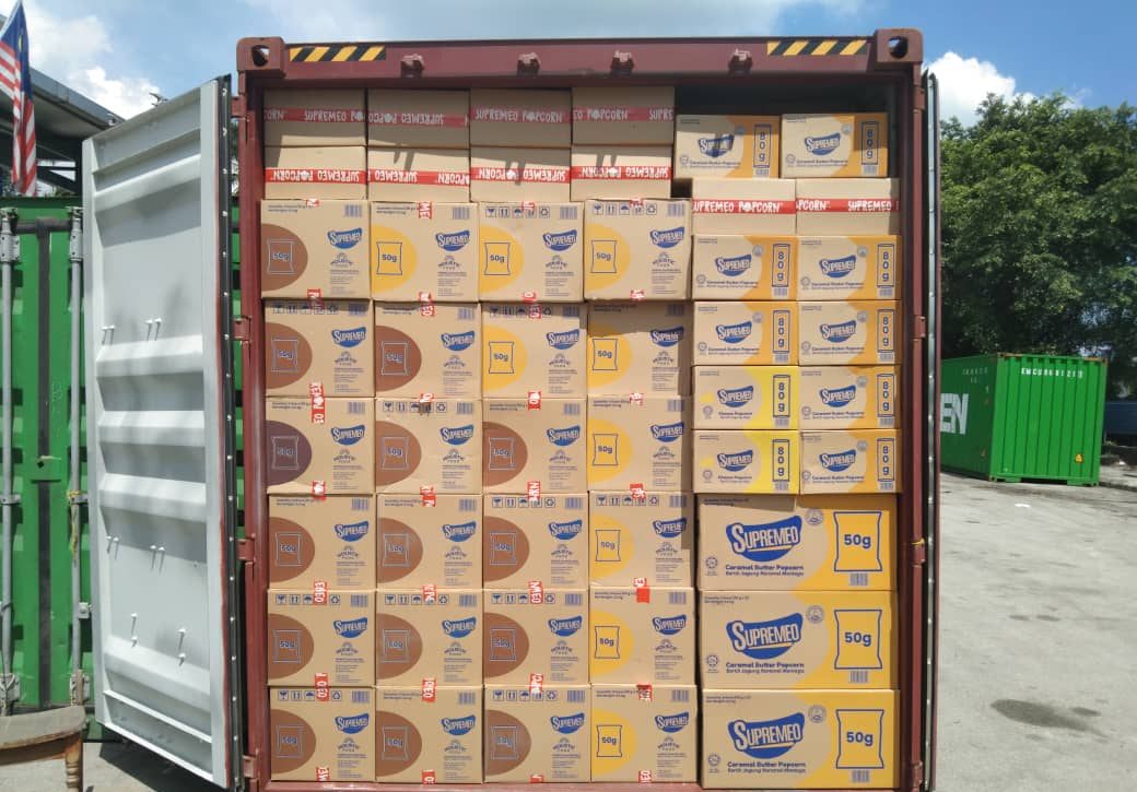 Malaysian-branded snack cartons loaded into a shipping container for export